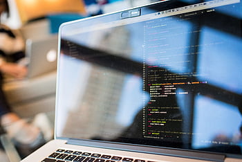 Laptop displaying code with reflection, perfect for tech and programming themes. HD wallpaper