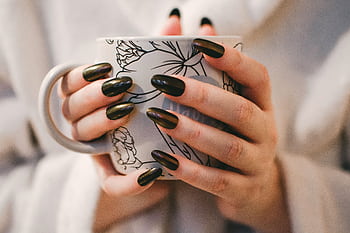 A close-up of manicured hands holding a decorative mug, perfect for lifestyle and coffee themes. HD wallpaper