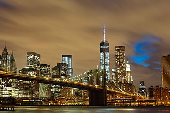 A stunning night view of New York City with the Brooklyn Bridge and illuminated skyline. HD wallpaper