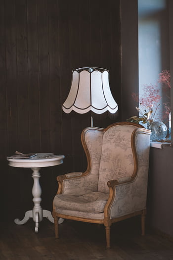 Charming vintage interior with an armchair, elegant lamp, and side table. Perfect for cozy settings. HD phone wallpaper