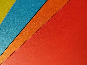 Close-up of vibrant, colorful paper sheets arranged in a geometric pattern, perfect for artistic backgrounds. HD wallpaper