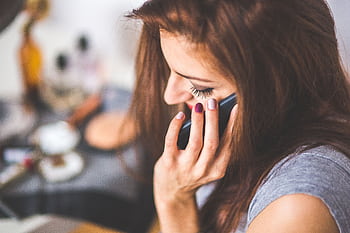 Close-up of a woman conversing on a smart indoors during the day. HD wallpaper