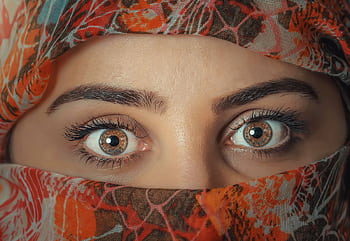 A striking close-up shot of a woman's eyes framed by a colorful headscarf, capturing beauty and mystery. HD wallpaper