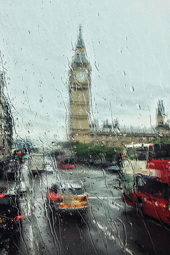Moody view of Big Ben through a rain-soaked window, capturing London's iconic weather and city life. HD phone wallpaper