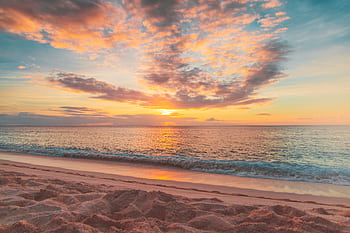 Serene sunset over a tranquil Hawaiian beach, capturing vibrant skies and ocean waves. HD wallpaper