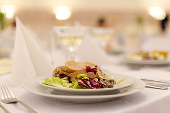 Plate of gourmet salad with bread on a elegantly set restaurant table, perfect for upscale dining experiences. HD wallpaper