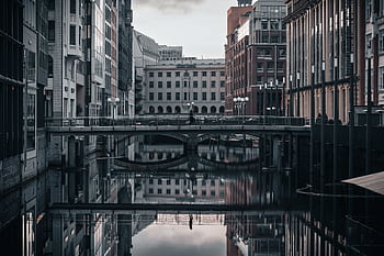 Urban scene capturing modern architecture reflecting on a calm canal in Hamburg, Germany. HD wallpaper