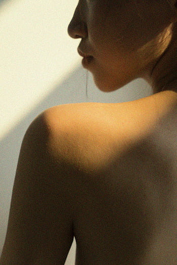 Artistic close-up of a woman's bare shoulder in soft lighting. HD phone wallpaper