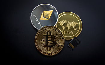 A striking of Bitcoin, Ethereum, and Ripple coins illustrating modern digital currency. HD wallpaper