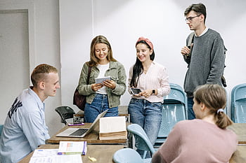 A diverse group of college students engaging in a lively study session indoors. HD wallpaper