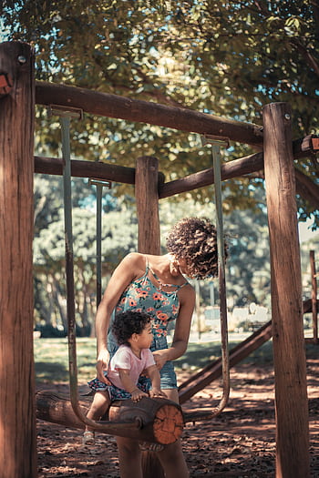 Joyful moment of a mother and child playing together in a sunny park, enjoying family time. HD phone wallpaper