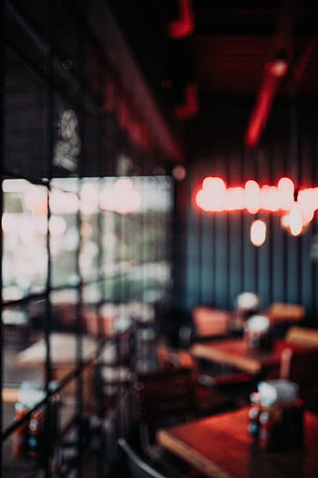 Cozy restaurant interior featuring modern furniture, blurred neon lights, and window views. HD phone wallpaper