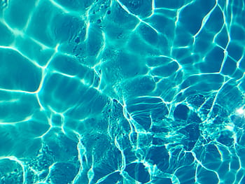 Bright turquoise water surface in sunlight, capturing shimmering patterns and reflections. HD wallpaper