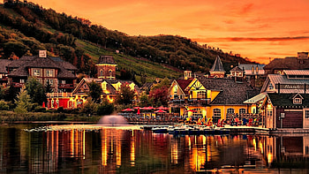 lakeside town at dusk, town, boats, fountain, mountainside, dusk, lake HD wallpaper