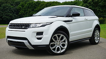 Stylish white Range Rover parked on a road in a green outdoor setting, showcasing its luxury design. HD wallpaper