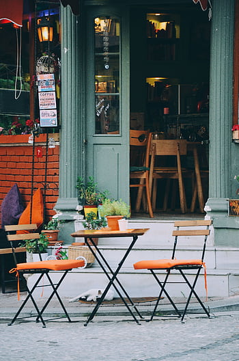 Cozy outdoor café with colorful chairs and rustic design. Ideal for travel and urban lifestyle ry. HD phone wallpaper
