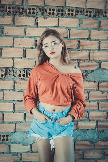 Fashionable woman in casual clothes posing against a brick wall. HD phone wallpaper