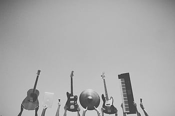 Musical instruments and tech raised in the air against a clear blue sky. HD wallpaper