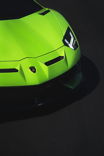 A striking close-up of a luxury green sports car's front bumper and headlights. HD phone wallpaper