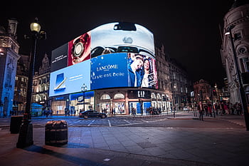 Night view of illuminated billboards at Piccadilly Circus, showcasing vibrant city life in London. HD wallpaper