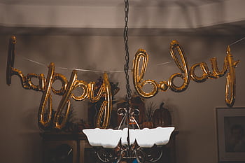 Festive gold balloons spelling 'happy bday' hang indoors, ideal for party themes. HD wallpaper