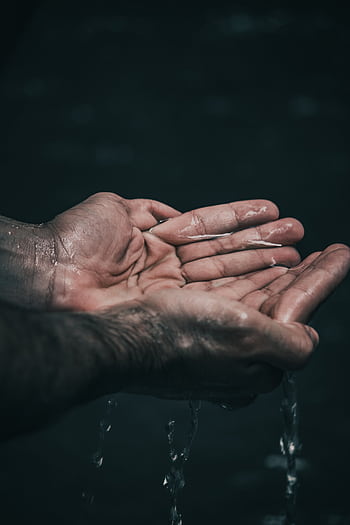 A dramatic shot of cupped hands holding water, highlighting water conservation themes. HD phone wallpaper