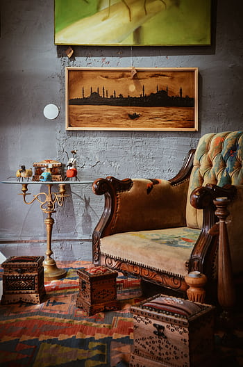 Cozy living room with a vintage armchair, artistic wall art, and wooden decor. HD phone wallpaper