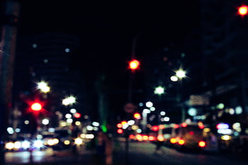 Blurred urban street with vibrant light streaks and traffic at night, showcasing motion and energy in city life. HD wallpaper