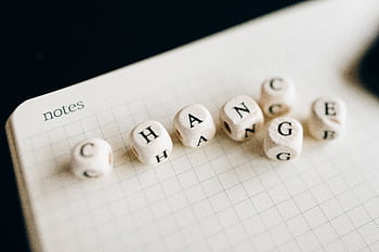 Close-up of letter dice spelling 'change' on a grid notepad, symbolizing transformation. HD wallpaper