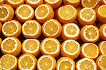 A vibrant array of freshly cut oranges showcasing their juicy interior. Perfect for healthy lifestyle themes. HD wallpaper