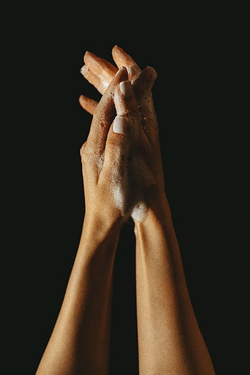 Close-up of hands lathered with soap against a black background, emphasizing hygiene and cleanliness. HD phone wallpaper