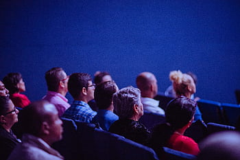 An attentive group of adults seated at an indoor conference, focusing on a presentation. HD wallpaper