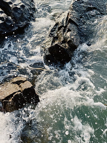 Dynamic ocean waves splashing against rugged rocks in Phu Quoc, Vietnam. HD phone wallpaper