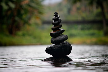 Balanced stones in a serene river evoke a sense of peace and tranquility. HD wallpaper