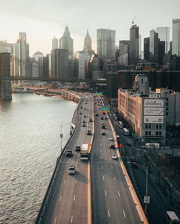 Stunning aerial shot of New York City's Manhattan skyline with a busy highway and river in view. HD phone wallpaper