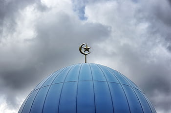 Blue mosque dome with crescent and star against a cloudy sky, showcasing modern Islamic architecture. HD wallpaper