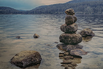 Peaceful lake scene at Schluchsee, Germany, showcasing rock balancing and scenic nature. HD wallpaper