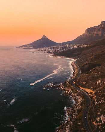 A breathtaking view of Cape Town's coastal road and Lion's Head at sunset, capturing the vibrant hues of the sky. HD phone wallpaper