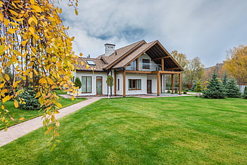 A beautiful suburban home with lush green lawn and autumn foliage. HD wallpaper