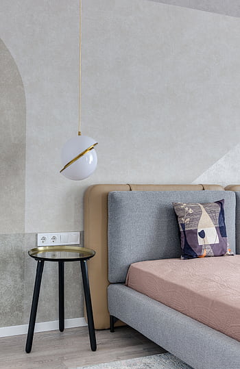 A sophisticated bedroom featuring contemporary decor with a gray bed, artistic pillow, and sleek pendant lamp. HD phone wallpaper