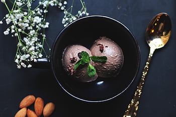 Delicious chocolate ice cream in a bowl garnished with mint leaves and almonds. HD wallpaper