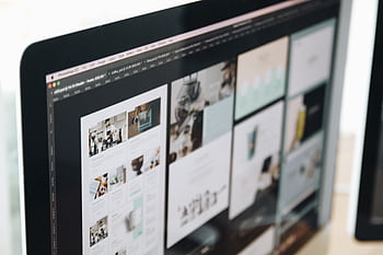 A modern computer screen displaying web design work, showcasing creative visuals in a workspace. HD wallpaper