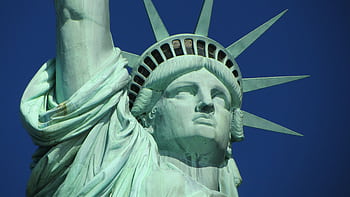 Detailed close-up of the Statue of Liberty against a clear blue sky. HD wallpaper