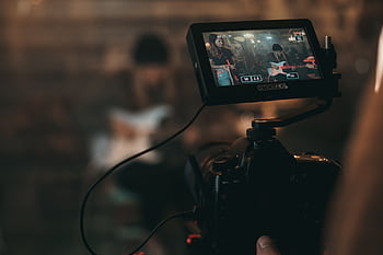 A cinematic close-up of filming a rock band performance with focus on camera screen. HD wallpaper