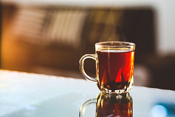 Enjoy a warm, steaming glass of tea in a cozy sunlit room, perfect for relaxation. HD wallpaper