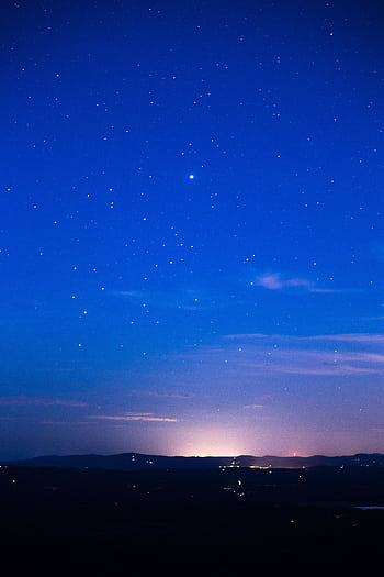 A serene night sky with countless stars sparkling above a dimly lit horizon. HD phone wallpaper