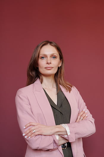 Elegant businesswoman with arms crossed in studio portrait, showcasing leadership and confidence. HD phone wallpaper