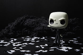 A creepy toy figure on a dark background adorned with eerie white shapes, ideal for Halloween themes. HD wallpaper