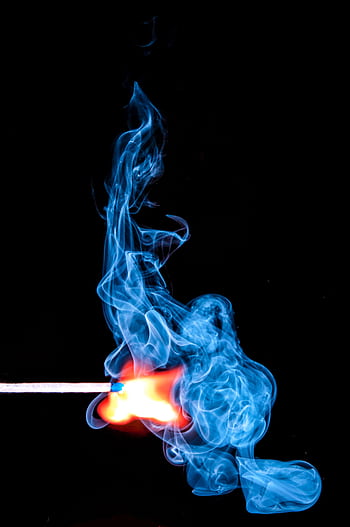 A match ignites with vibrant blue smoke against a black background. HD phone wallpaper