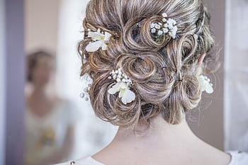 Close-up of an elegant bridal hairstyle featuring delicate white flowers, perfect for a wedding day. HD wallpaper